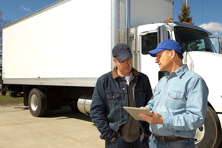 Two people talking in front of trucks